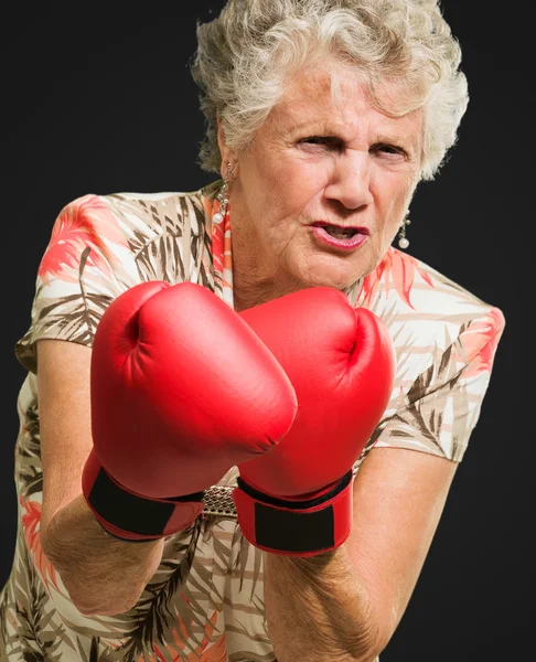 Mujer madura enojada usando guante de boxeo —  Fotos de Stock