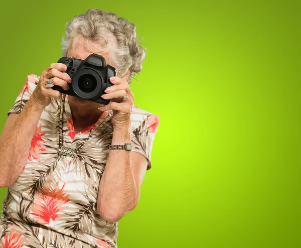 Seniorin blickt durch Kamera — Stockfoto