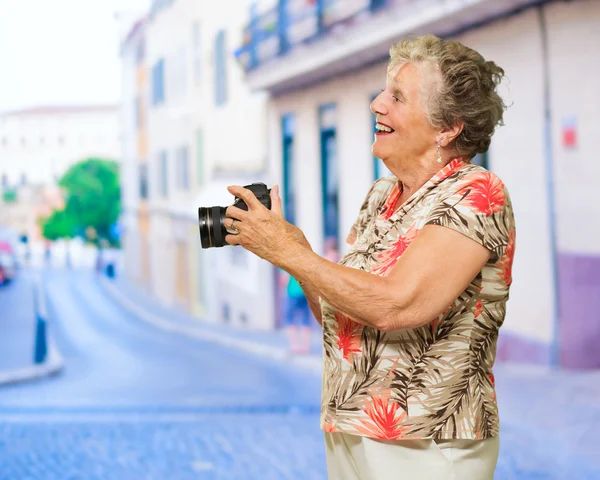 Mujer mayor feliz sosteniendo la cámara — Foto de Stock