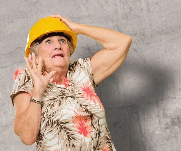 Com medo de mulher sênior vestindo Hardhat — Fotografia de Stock