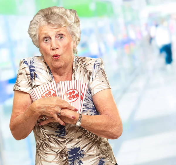 Seniorin hält Popcorn in der Hand — Stockfoto