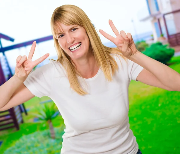 Glückliche Frau zeigt Friedenszeichen — Stockfoto