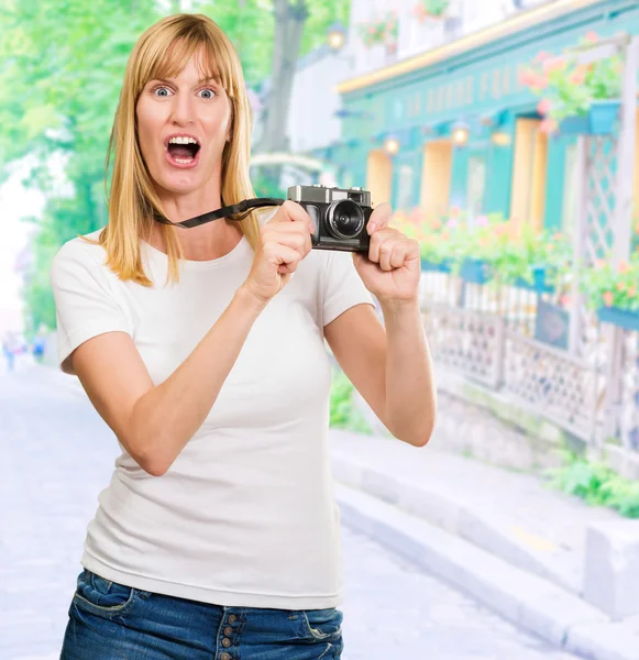 Geschokt vrouw met oude camera — Stockfoto