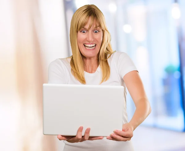 Donna felice guardando il computer portatile — Foto Stock