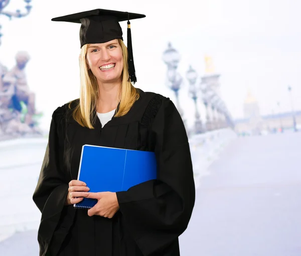 Gelukkig afgestudeerde vrouw met een notebook — Stockfoto