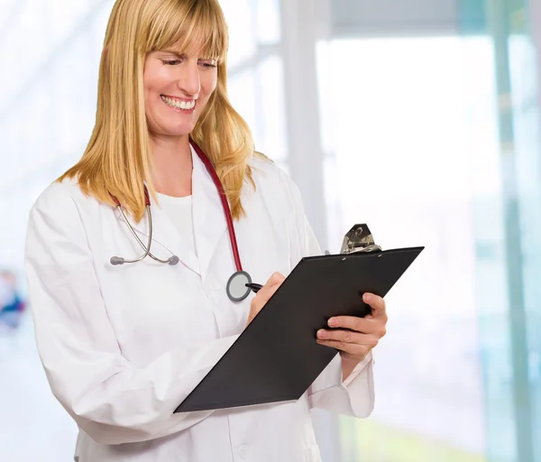 Retrato de feliz médico escrevendo na área de transferência — Fotografia de Stock