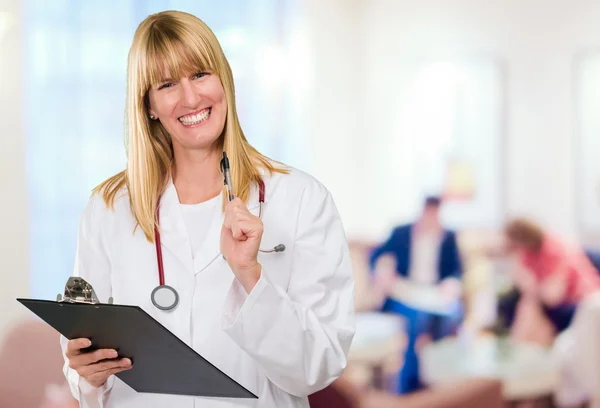 Feliz médico femenino sosteniendo un portapapeles — Foto de Stock