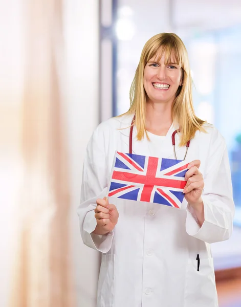 Mutlu doktor holding İngiliz bayrağı — Stok fotoğraf