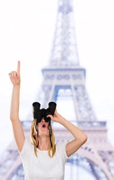 Frau blickt durch Fernglas und zeigt nach oben — Stockfoto