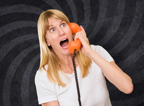 Shocked woman talking on telephone — Stock Photo, Image