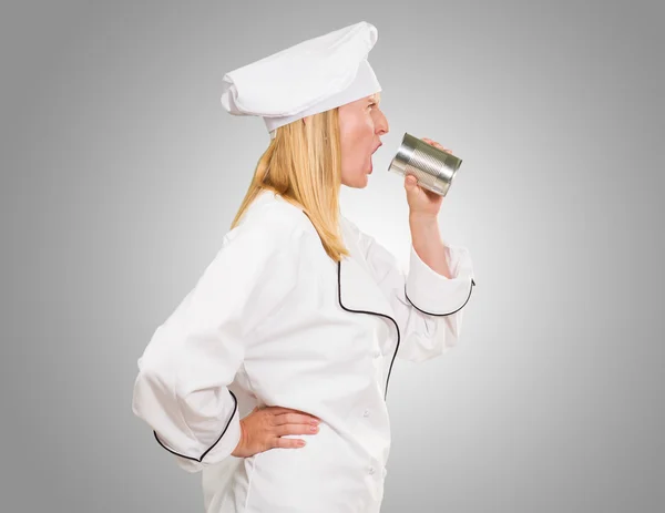 Ženské šéfkuchař drží plechovou křik — Stock fotografie