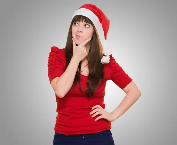 Frau denkt und trägt Weihnachtsmütze — Stockfoto