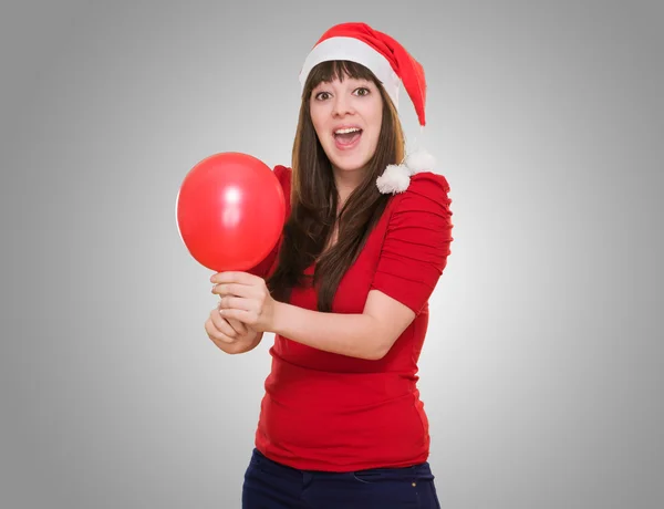 Mujer sorprendida vistiendo un sombrero de Navidad y sosteniendo un globo — Foto de Stock