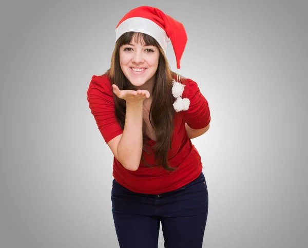 Mulher vestindo um chapéu de Natal e soprando um beijo — Fotografia de Stock