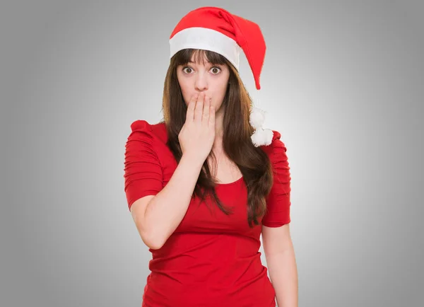 Donna indossando un cappello di Natale e coprendo la bocca — Foto Stock