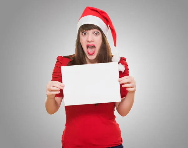 Surprised christmas woman holding a blank card — Stock Photo, Image