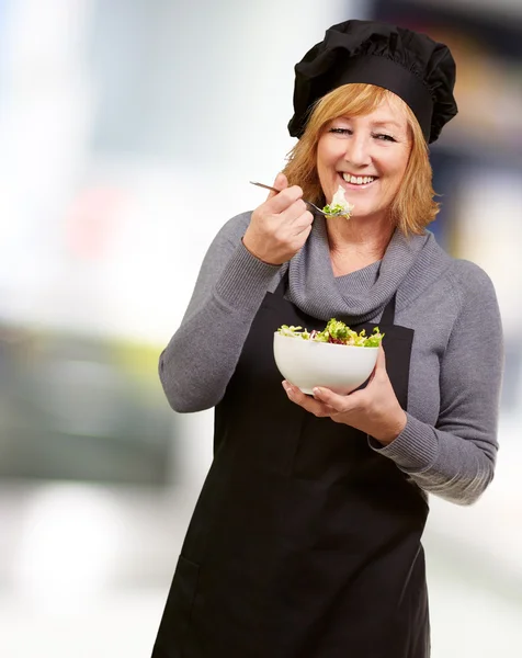Egy magas rangú nő eszik saláta — Stock Fotó