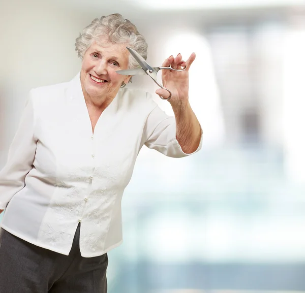 Seniorin hält Schere in der Hand — Stockfoto