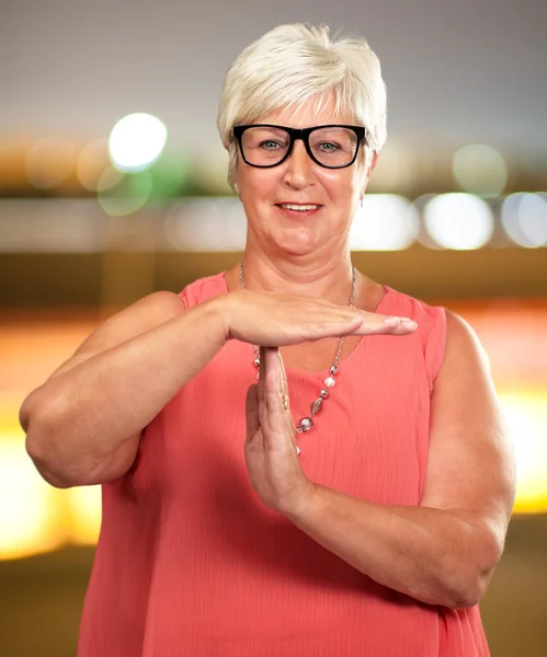 Retrato de uma mulher sênior mostrando sinal Time Out — Fotografia de Stock