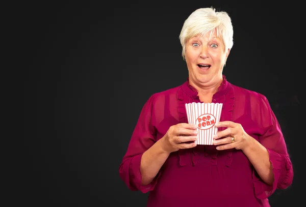 Vieille femme manger du pop-corn — Photo