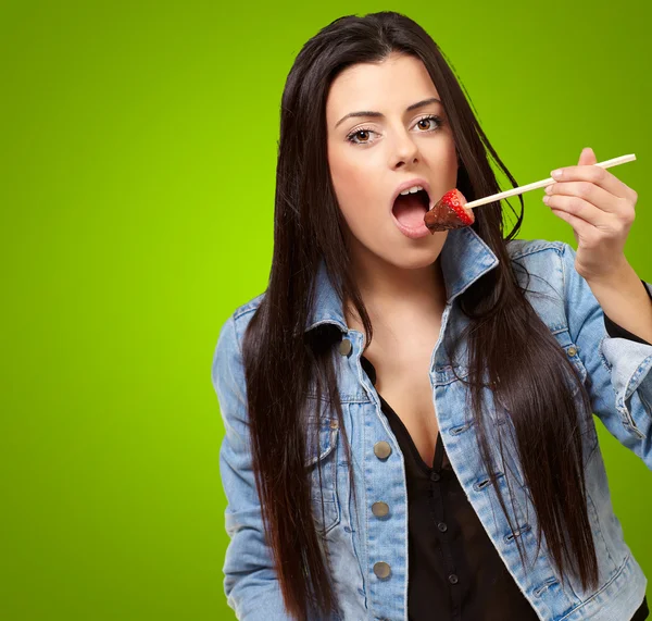 Retrato de uma fêmea comendo morango com molho de chocolate — Fotografia de Stock