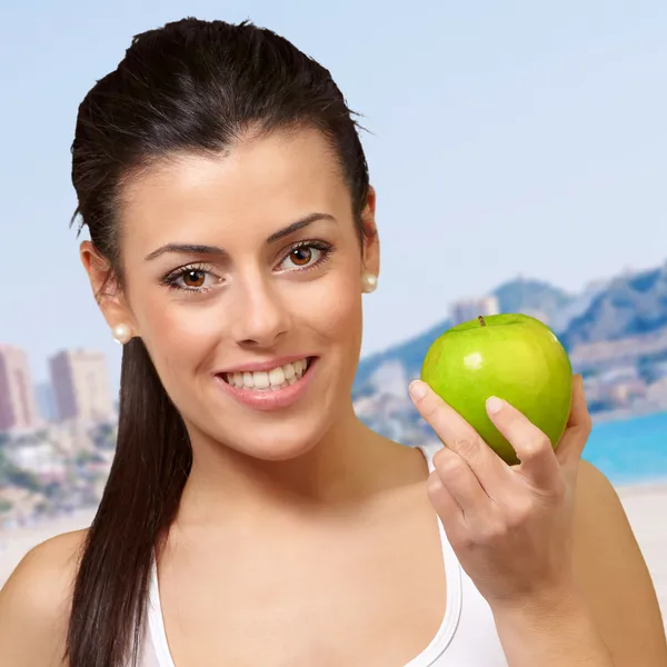 Mujer joven sosteniendo una manzana — Foto de Stock