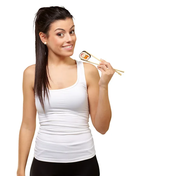 Ung flicka håller sushirulle med pinnar — Stockfoto