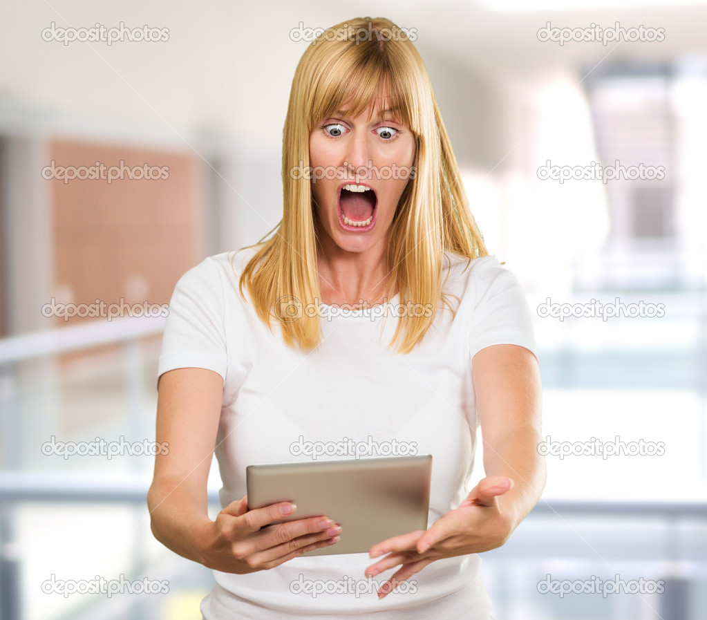 Shocked Woman Looking At Digital Tablet