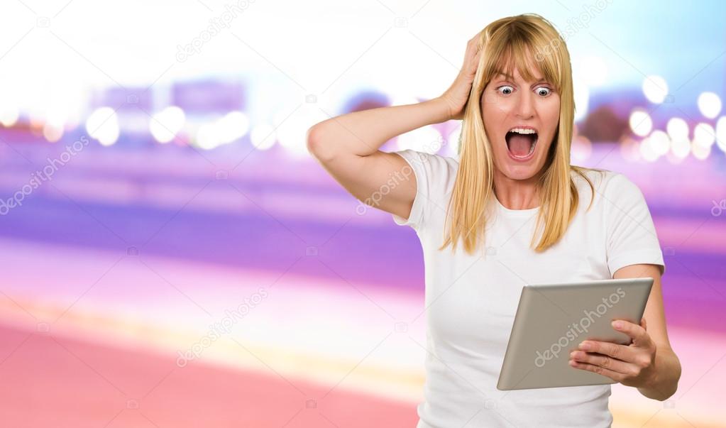 Shocked Woman Looking At Digital Tablet