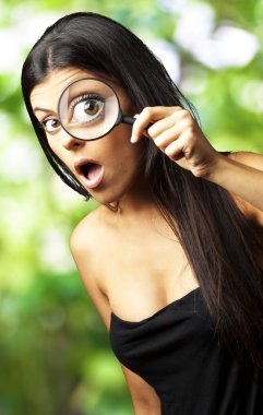 genç kadın bir büyüteç karşı bakarak şaşırttı