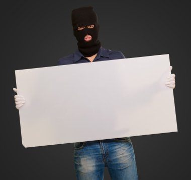 Portrait of a man wearing mask holding blank card clipart