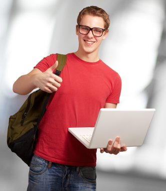 adam tutarak laptop ve sırt çantası