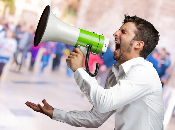 Portret van een man schreeuwen in een megafoon — Stockfoto