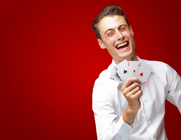 Retrato de homem jovem mostrando cartas de poker — Fotografia de Stock