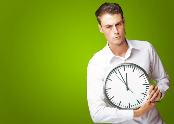 Hombre enojado sosteniendo un reloj —  Fotos de Stock