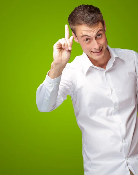 Retrato de um jovem sorridente apontando para cima — Fotografia de Stock