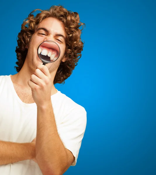 Hombre examinando sus dientes con lupa — Foto de Stock