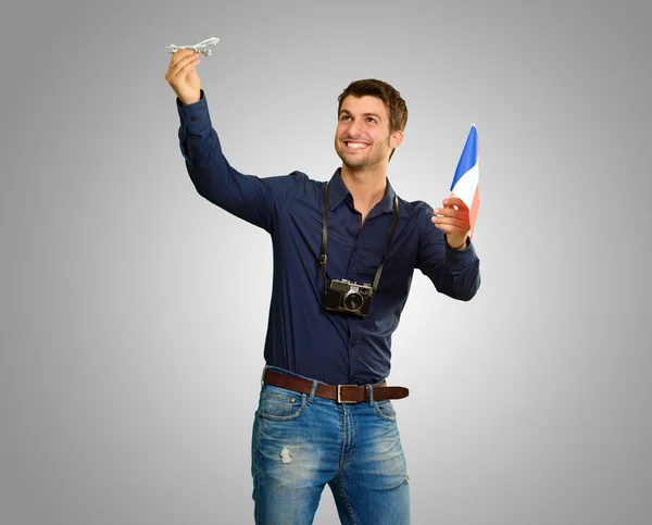 Homem segurando bandeira e miniatura de avião — Fotografia de Stock