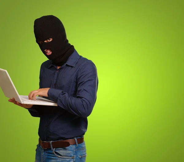 Young male thief holding laptop — Stock Photo, Image