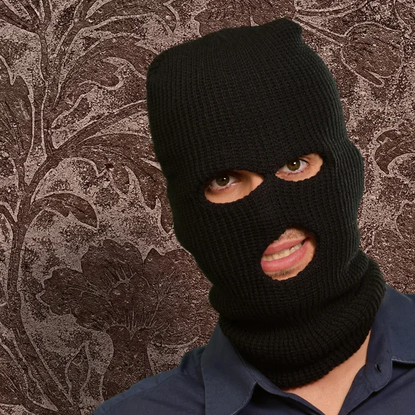 Un hombre con una máscara de ladrón mostrando un papel en blanco — Foto de Stock
