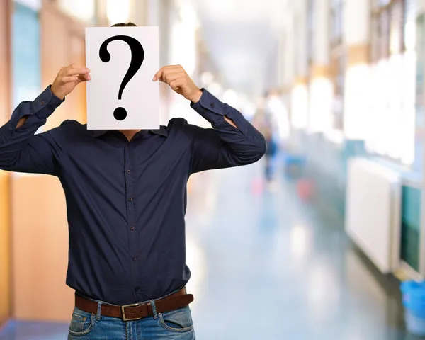 Man standing with a question mark board — Stock Photo, Image