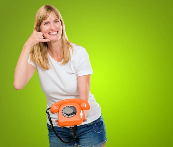 Mulher segurando telefone e fazendo um gesto — Fotografia de Stock