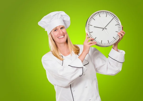 Chef femenino que sostiene el reloj — Foto de Stock