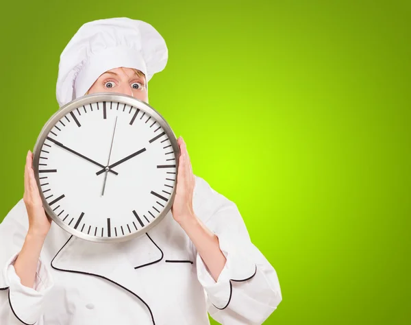 Femme chef caché derrière une horloge — Photo