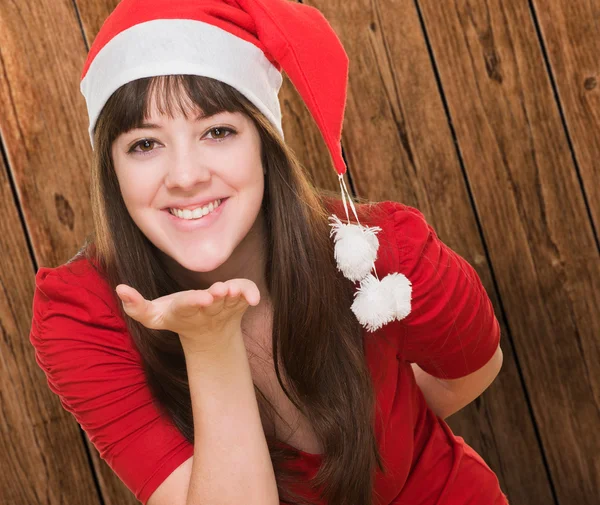 Vrouw dragen een kerstmuts en blaast een kus — Stockfoto