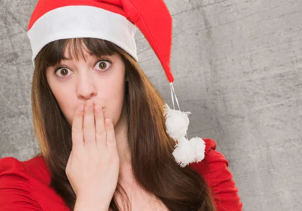Woman wearing a christmas hat and covering her mouth — Stock Photo, Image