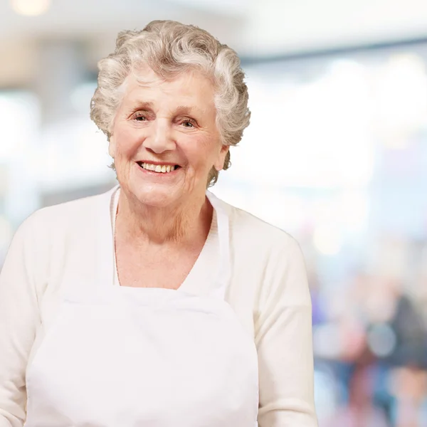 Portrait de cuisinière senior sur fond abstrait — Photo