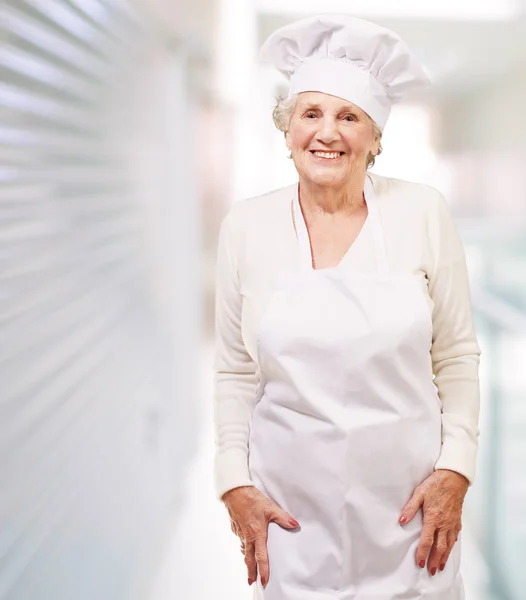 Portret van cook senior vrouw die lacht in restaurant — Stockfoto