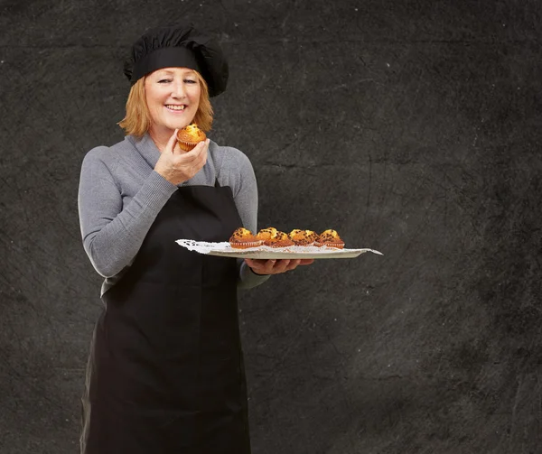 Portret van Midden leeftijd cook vrouw met een zelfgemaakte muffin aga — Stockfoto