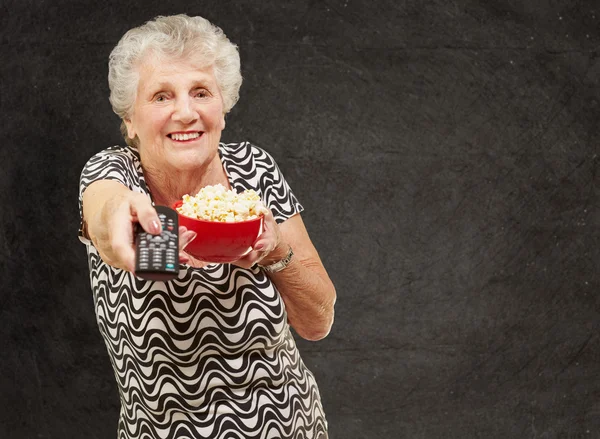 Porträt einer Seniorin mit Popcorn-Schale und wechselndem Chan — Stockfoto